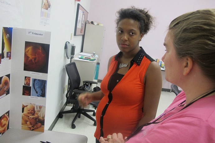 Lawrencea Myles, 21, looks over a fetal development chart with Michelle Uttke, a registered nurse. (Photo by Edgar Mendez)