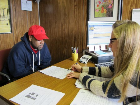 Supervisor Angela Catania explains how to regain a driver’s license to Hakim Fudge, who has 15 unpaid tickets, at the Center for Driver's License Recovery and Employability. (Photo by Rick Brown)