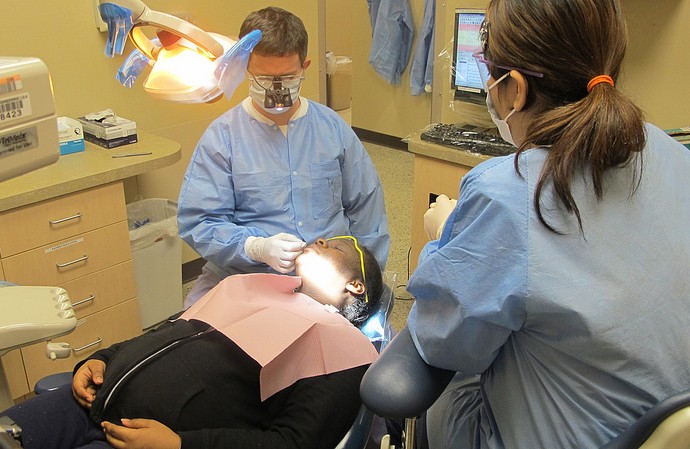 Seton Dental Clinic’s full-time staff dentist Charles Kosowski works on patient Diamond Carter’s teeth. (Photo by Andrea Waxman)