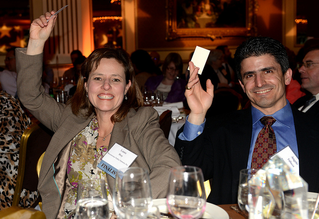 Menomonee Valley Partners Executive Director Laura Bray and Palermo Villa Chief Operating Officer Angelo Fallucca wave their business cards to enter a raffle at the MANDI celebration. Menomonee Valley Partners won the Brewers Community Foundation Public Space Award for Three Bridges Park. (Photo by Sue Vliet)