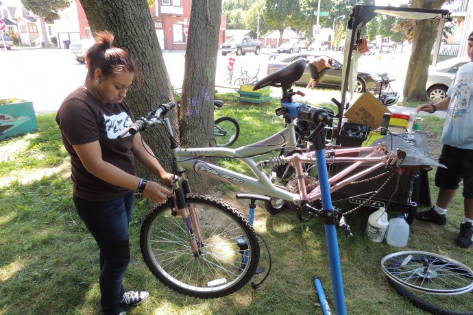 Diana Gutierrez works on a bicycle as part of her internship with the Mobile Bike Hub. (Photo by Layton Boulevard West Neighbors) 