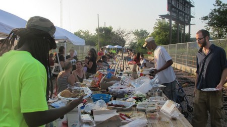 Harambee and Riverwest neighbors shared a community potluck dinner at a 100-foot table set up on a pedestrian bridge at the end of the artery. (Photo by Andrea Waxman) 