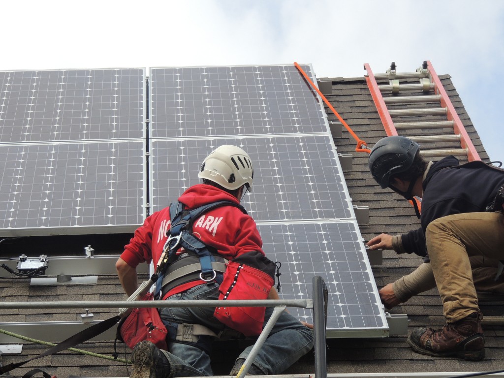 Workers install solar energy equipment on a roof in the Burnham Park neighborhood. (Photo courtesy of Layton Boulevard West Neighbors)