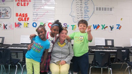 Maureen Sullivan, principal of Woodlands East, poses with students after music class. (Photo by Molly Rippinger)