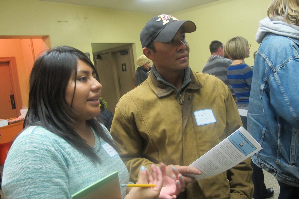 Alex Hernandez (left) provides information about revitalization efforts to neighborhood resident Martin Carpio at a recent open house at the Pulaski pavilion. (Photo by Edgar Mendez)