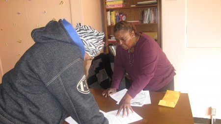Outreach worker Shavon Pope helps a program participant update her personal information. (Photo by Andrea Waxman)