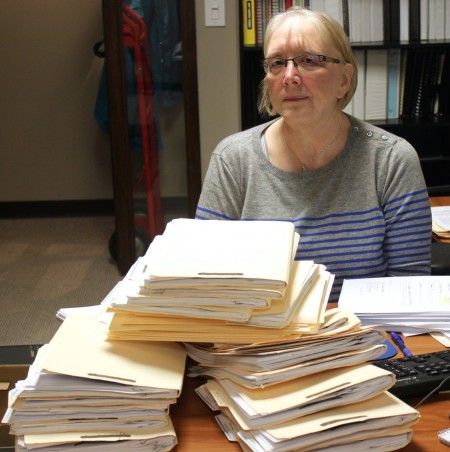 Dorothy Dean, a volunteer at Metropolitan Milwaukee Fair Housing Council, follows up on stacks of mortgage rescue scam cases. (Photo by Matthew Wisla)