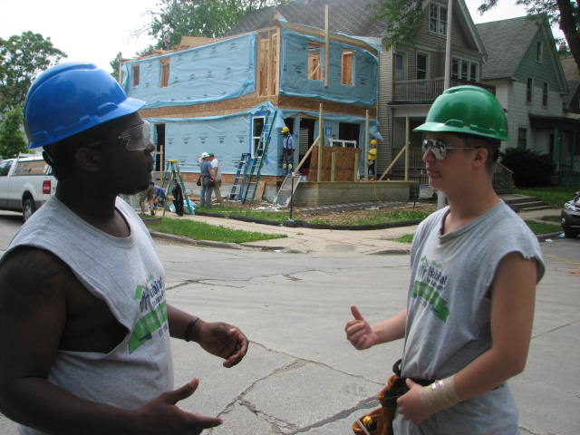 YouthBuild participants Deshawn Washington (left) and Michael Merkel discuss the house they helped build with Milwaukee Habitat for Humanity. (Photo by Brendan O’Brien)
