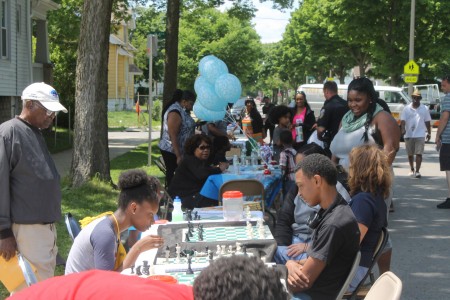 Amani residents play chess at a block party on Chambers between 23rd and 24th streets. (Photo by Madeline Kennedy)