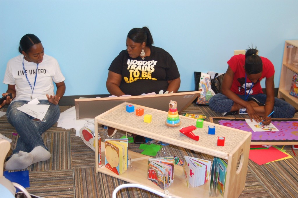 Burke Center teachers (from left): Lashaunda Payton, LaDonna Walton and Madelyn Evans prepare bulletin boards for the new classrooms. (Photo by Andrea Waxman)