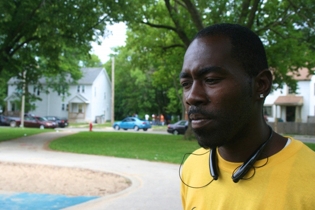 Teddy Ellis stands in Garden Homes Park while a group of neighborhood youth gamble across the street. (Photo by Jabril Faraj)