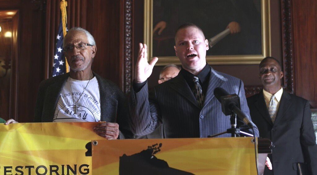 Mark Rice (at microphone) speaks at a press conference at the State Capitol to launch the ROC Wisconsin campaign on Nov. 3. He is joined by EXPO leaders Jerome Dillard (left) and William Harrell (background).