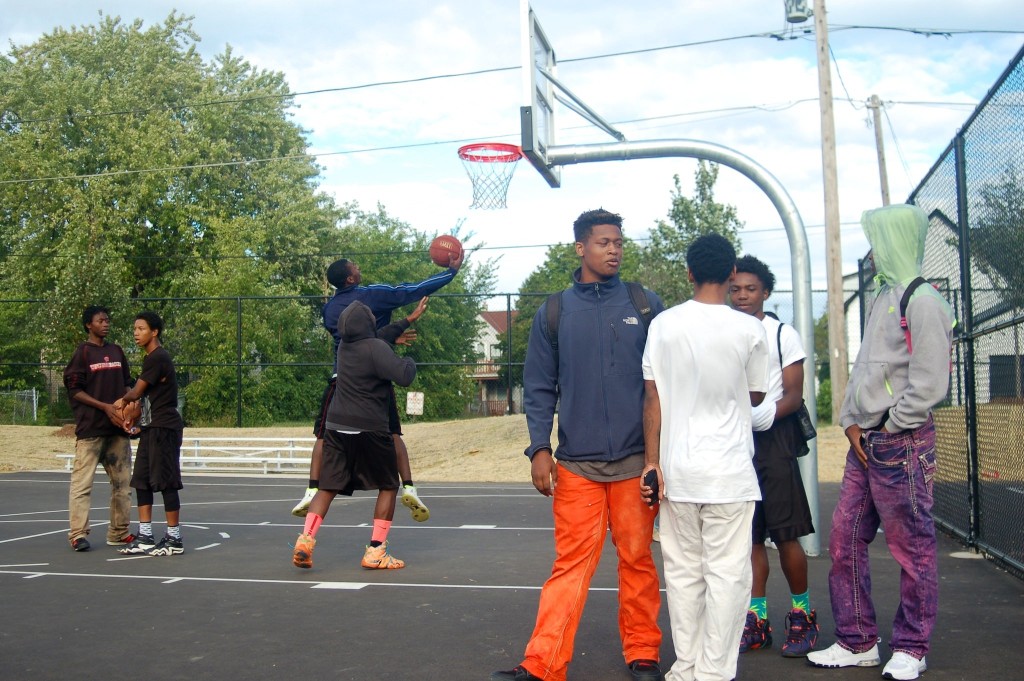 Young men wait their turn to play basketball during the opening day celebration at Moody Park. (Photo by Edgar Mendez)
