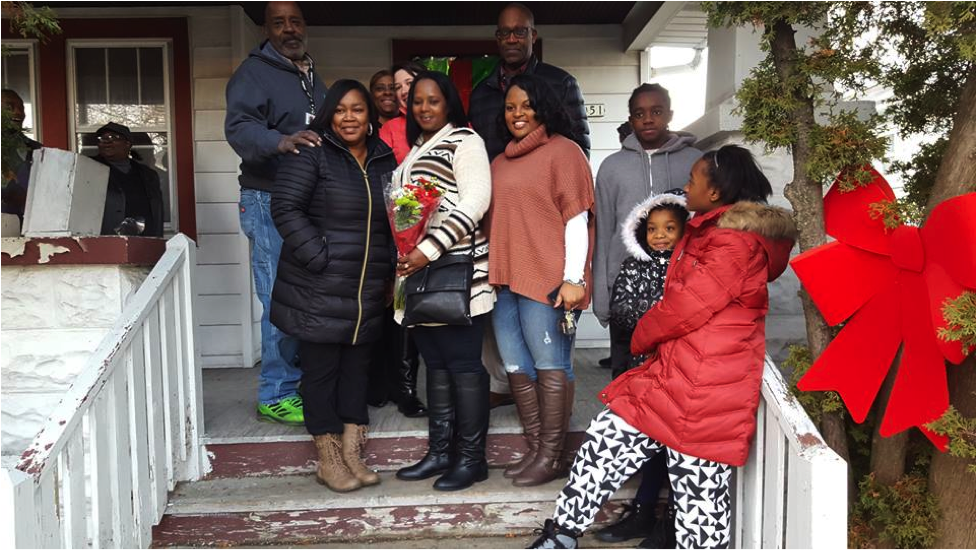 The Burkes family with ACTS Housing team members posing in front of her new home. (Photo courtesy of ACTS Housing)