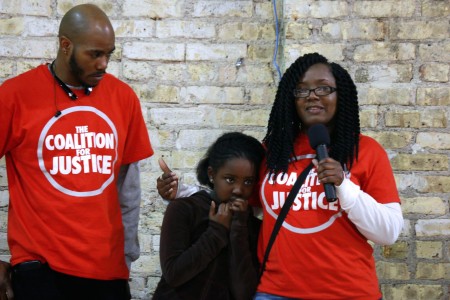 Markasa Chambers (left) and Nate Hamilton, co-founder of the Coalition for Justice, comfort Zoe Chambers, 8, as she tries to speak to the group. (Photo by Jimmy Gutierrez)