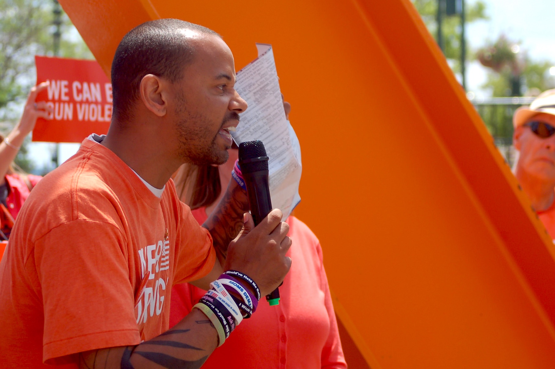 Khary Penebaker, a candidate for U.S. Congress, holds his mother’s death certificate as he tells a crowd at a gun violence awareness rally about her suicide in 1979. (Photo by Brendan O’Brien)