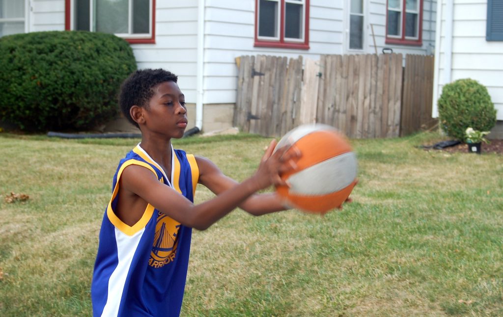 J'Ali Thornton practices with a basketball in front of his house. (Photo by Andrea Waxman)