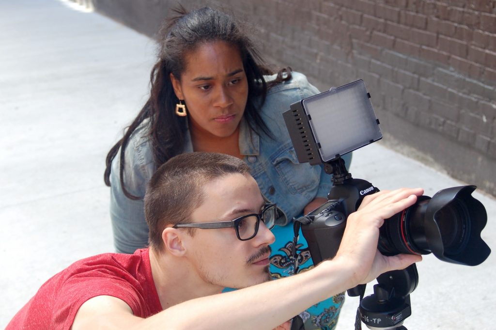 Tyshun Wardlaw directs videographer Mitchell Mittelstedt as he films a muralist working in Black Cat Alley, on the East Side. (Photo by Andrea Waxman)