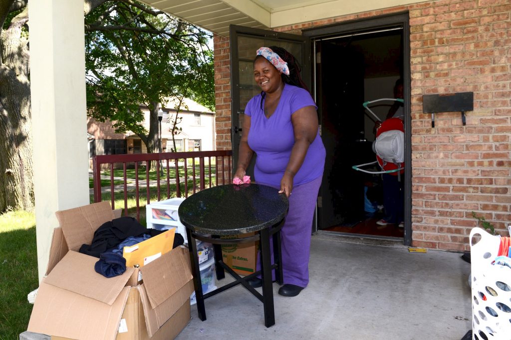 Mateka Young carries a table out of her apartment at 6701 W. Silver Spring Drive. Young was among the first residents to move out of the western section of Westlawn. (Photo by Sue Vliet)