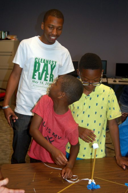 Que El-Amin looks on as David Luckett (left) and Robert Cotton Jr. work on an activity. (Photo by Andrea Waxman)