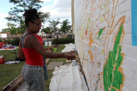 Artist Tia Richardson works on the mural. (Photo by Rebecca Carballo)