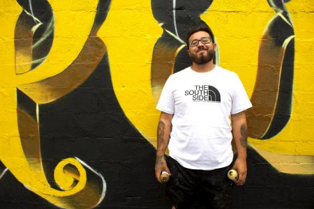 Chacho Lopez stands by his most recent mural in Walker’s Point during an early stage in its creation. (Photo by Emmy A. Yates)