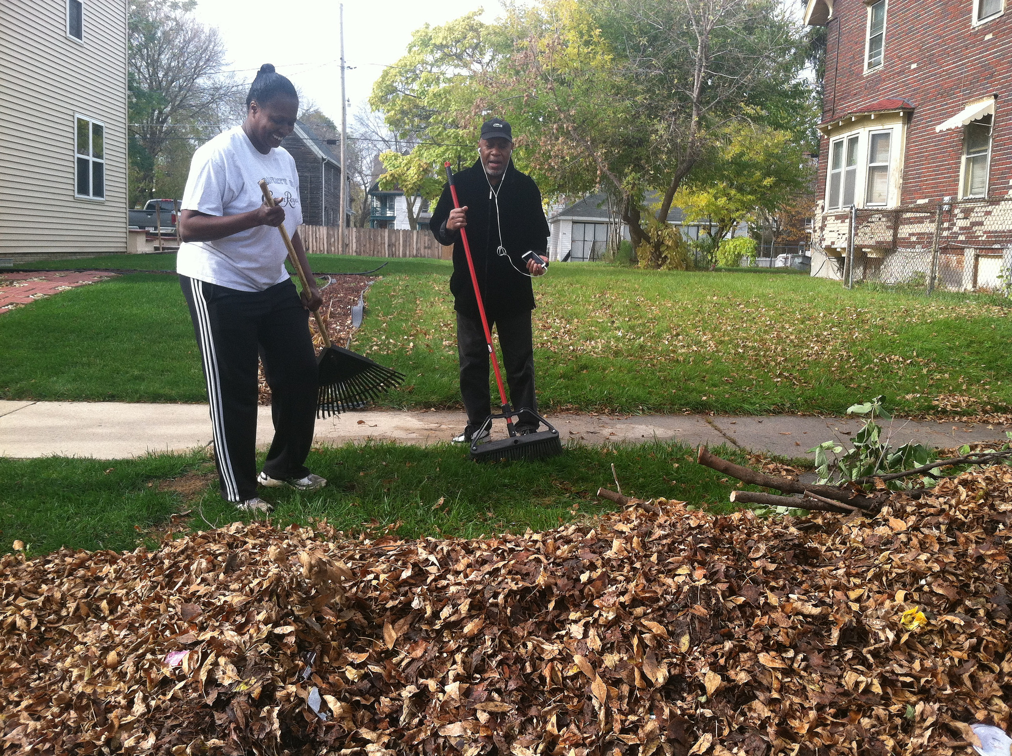 Gladys Carroll-Weathersby, resident, and Jack Hill, son of a resident, raking leaves on the 2400 block of N. 16th Street