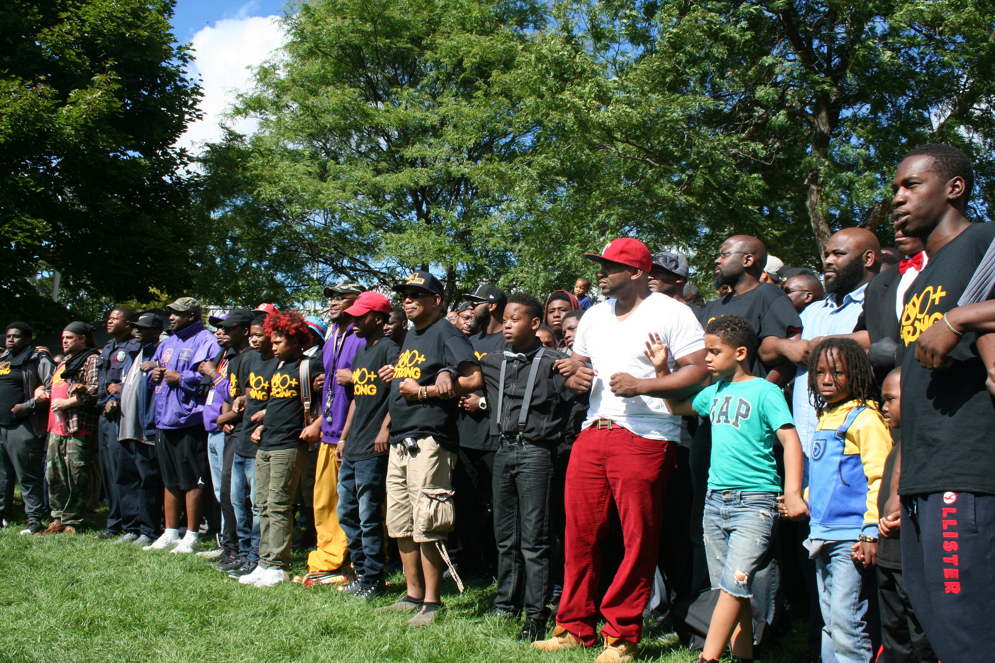 Black men and boys lock arms at the event. (Photo by Jabril Faraj)