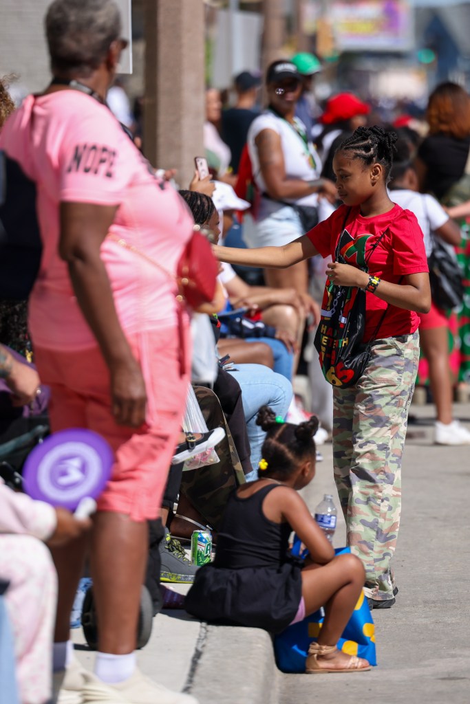 A participant of the parade hands out candy to attendees during the 55th Juneteenth Jubilee Parade on Friday, June 19, 2026 in Milwaukee. (Photo by Jonathan Aguilar / Milwaukee Neighborhood News Service / CatchLight Local)