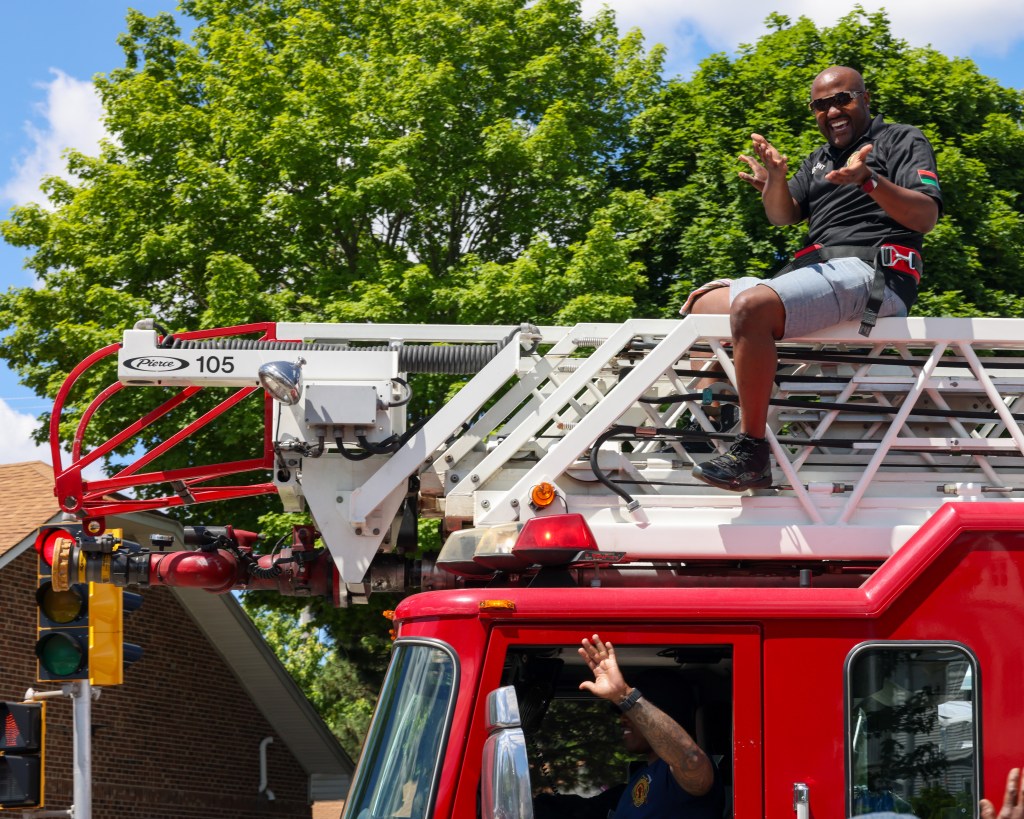 A Milwaukee firefighter rides on top of a firetruck during the 55th Juneteenth Jubilee Parade on Friday, June 19, 2026 in Milwaukee. (Photo by Jonathan Aguilar / Milwaukee Neighborhood News Service / CatchLight Local)