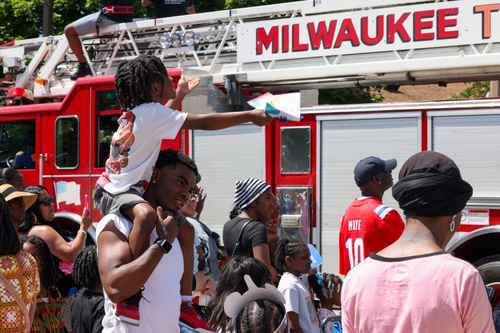 A child watches as a firetruck drives by during the 55th Juneteenth Jubilee Parade on Friday, June 19, 2026 in Milwaukee. (Photo by Jonathan Aguilar / Milwaukee Neighborhood News Service / CatchLight Local)