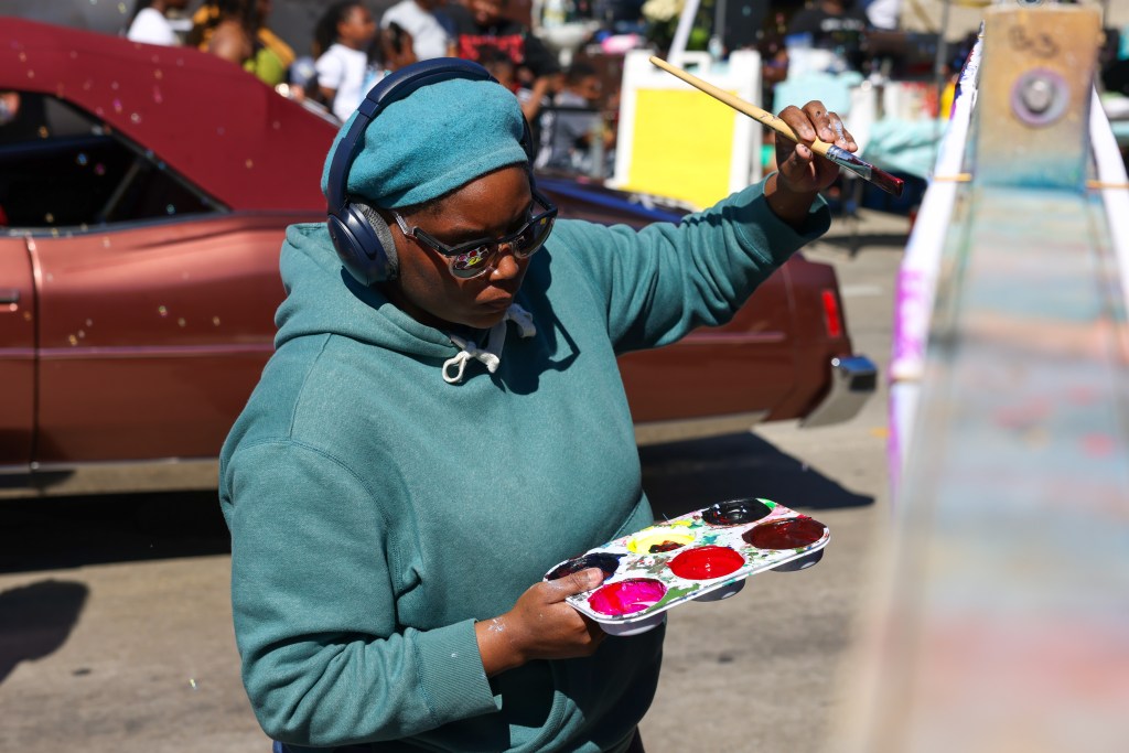 An artist works on a mural during the TRUE Skool Juneteenth mural contest during the 55th Juneteenth Jubilee Parade on Friday, June 19, 2026 in Milwaukee. (Photo by Jonathan Aguilar / Milwaukee Neighborhood News Service / CatchLight Local)