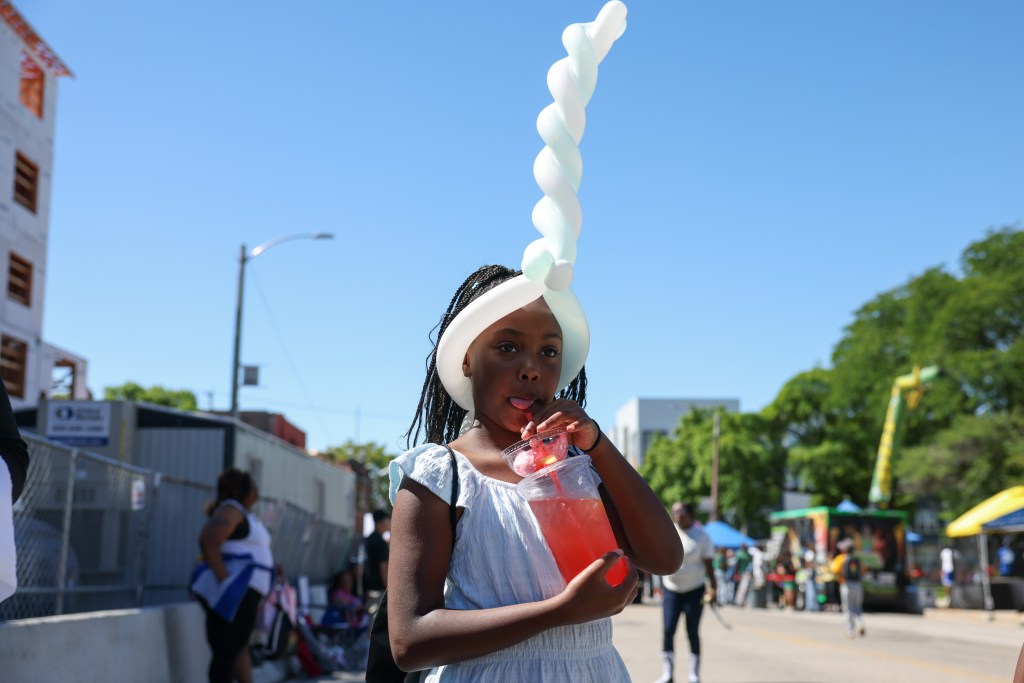 A child drinks a beverage during the 55th Juneteenth Jubilee Parade on Friday, June 19, 2026 in Milwaukee. (Photo by Jonathan Aguilar / Milwaukee Neighborhood News Service / CatchLight Local)