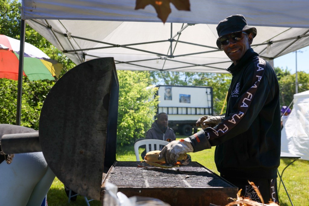 A person takes corn off the grill during the 55th Juneteenth Jubilee Parade on Friday, June 19, 2026 in Milwaukee. (Photo by Jonathan Aguilar / Milwaukee Neighborhood News Service / CatchLight Local)