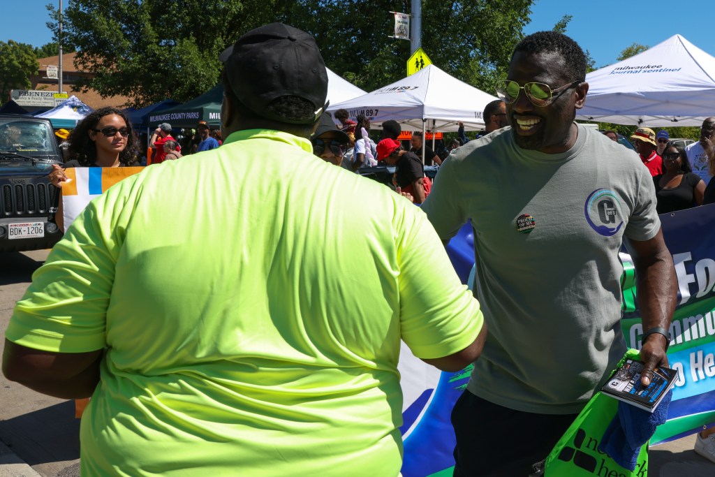 Gee Smith, owner of Gee’s Clippers, shakes hands with a person during the 55th Juneteenth Jubilee Parade on Friday, June 19, 2026 in Milwaukee. (Photo by Jonathan Aguilar / Milwaukee Neighborhood News Service)